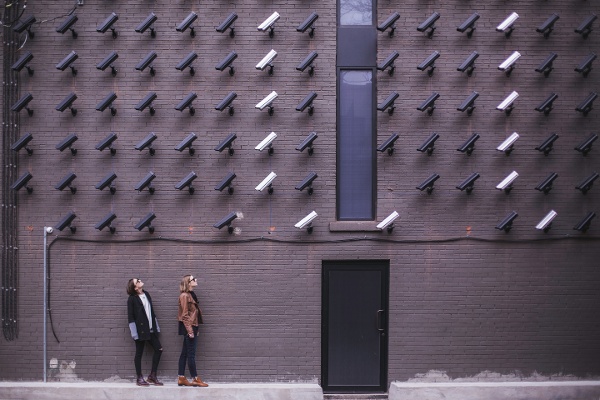 kaksi henkilöä seisoo kymmenien valvontakameroiden kuvattavana Matthew Henry Unsplash