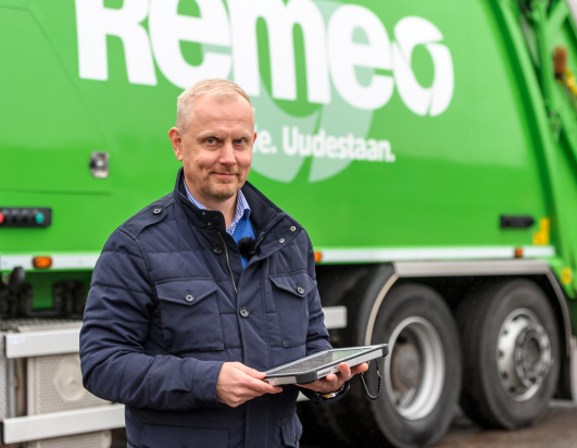 Remeo-aluejohtaja Kimmo Käenmäki jäteauton edessä Toughpad kädessä