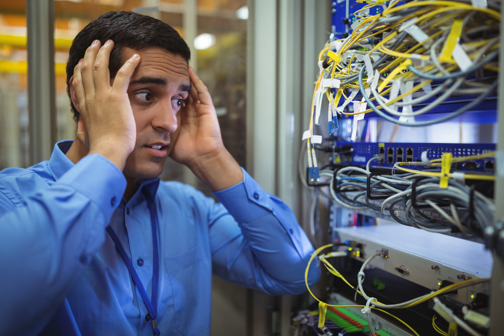 Technician getting stressed over server maintenance in server room