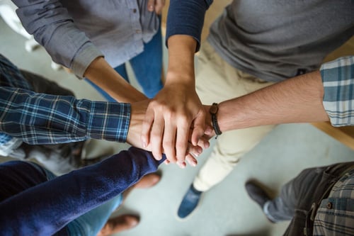 ihmiset liittävät kädet yhteen symbolina yhteistyöstä Kuva Shutterstock