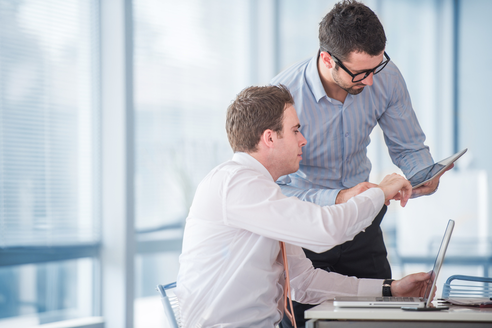 Two businessmen at work with a tablet in office