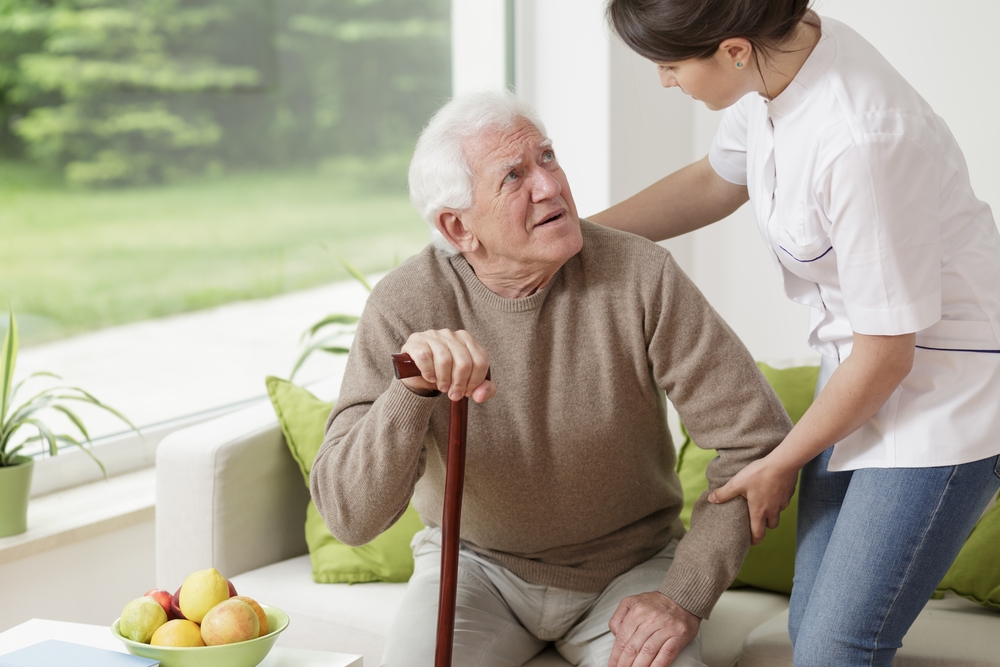 Young woman helping old man to stand up Image: Shutterstock