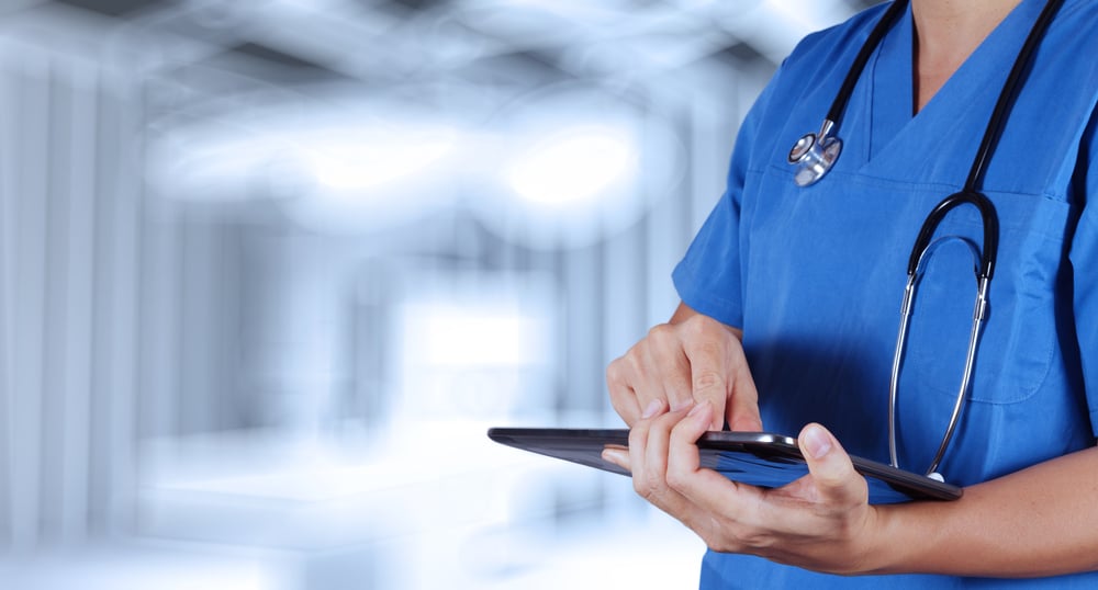 terveydenhuollon ammattilainen käyttää tablettia leikkaussaliympäristössä Kuva Shutterstock
