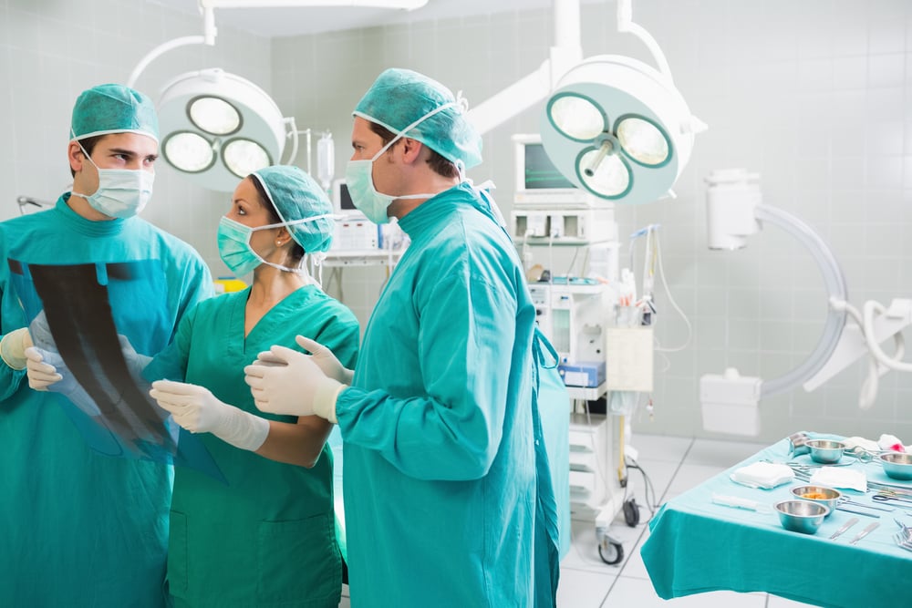 Medical team speaking of a X-ray in an operating theatre Image: Shutterstock